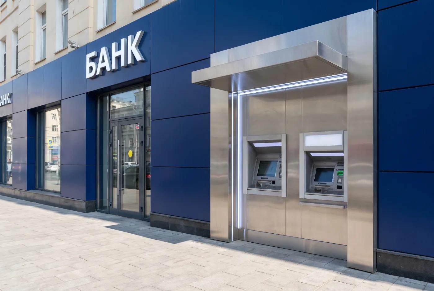 Банковский фасад с зоной банкоматов 24/7 — AI-рендер: встроенная ATM-ниша с козырьком, нержавеющие бортики, подсветка ниши, корпоративный синий цвет АКП