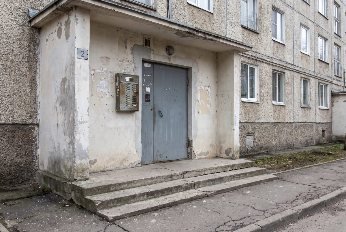 Входная зона подъезда МКД до ремонта — старые двери, облупленная штукатурка