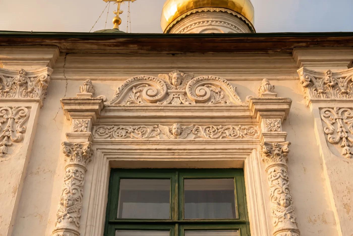 Наличник окна и барабан купола православного храма — декоративные детали фасада крупным планом Деталь наличника окна и барабан купола православного храма — белый резной декор, золотой купол — AI-визуализация