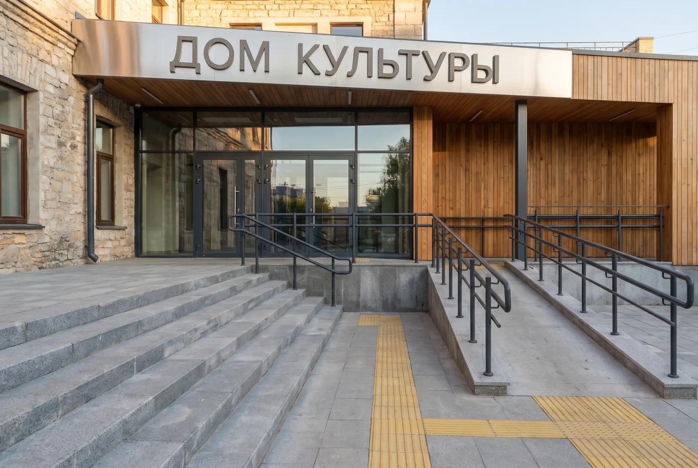 Входная площадь и группа дома культуры — крупный план с МГН-элементами Входная группа дома культуры крупным планом — широкие ступени, пандус МГН, тактильная навигация, вывеска ДОМ КУЛЬТУРЫ, флагштоки