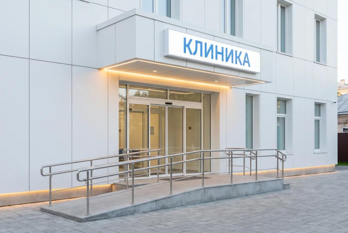 Медицинская клиника Входная группа медицинской клиники: белый минимализм, широкие автодвери, пандус — AI-рендер
