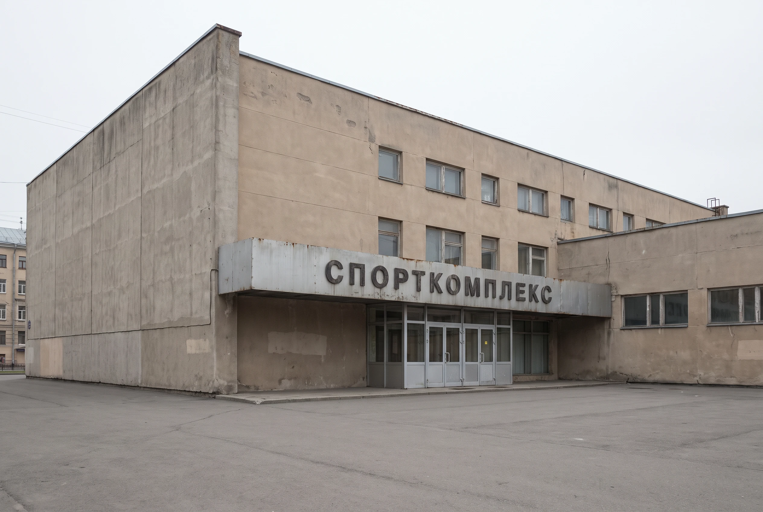 Фасад спортивного комплекса до реновации — устаревшее здание с невыразительной отделкой, глухие стены, старая вывеска